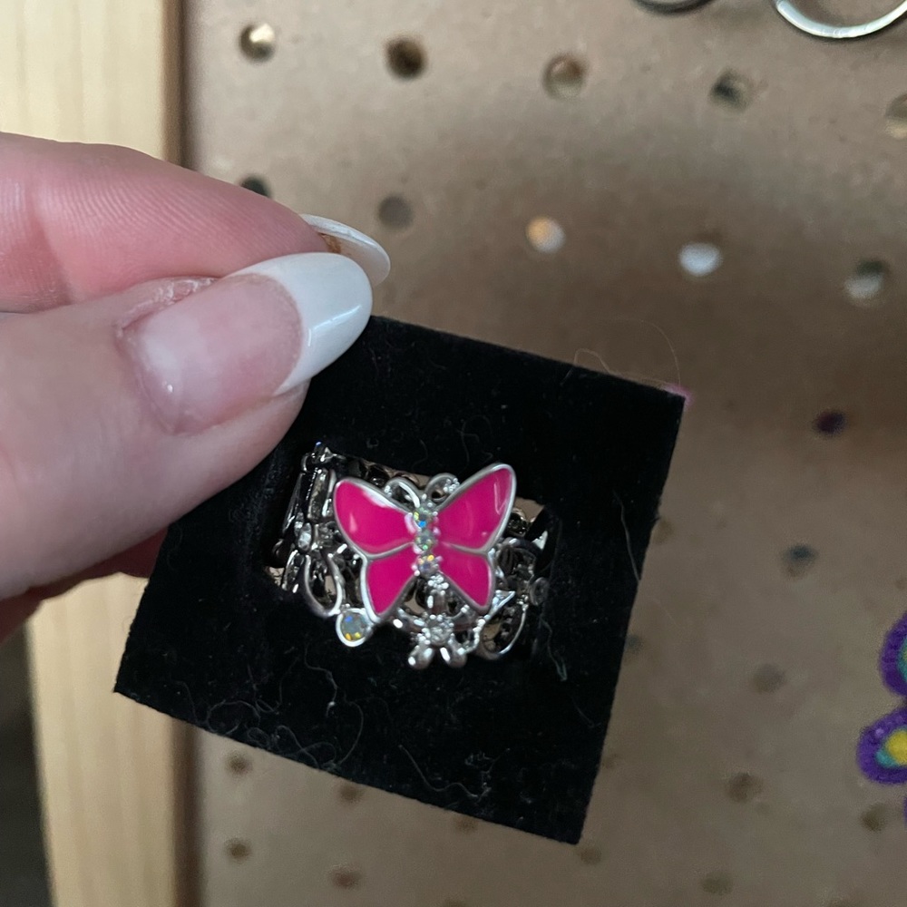 Silver tone stretchy back ring with hot pink butterfly accent.
